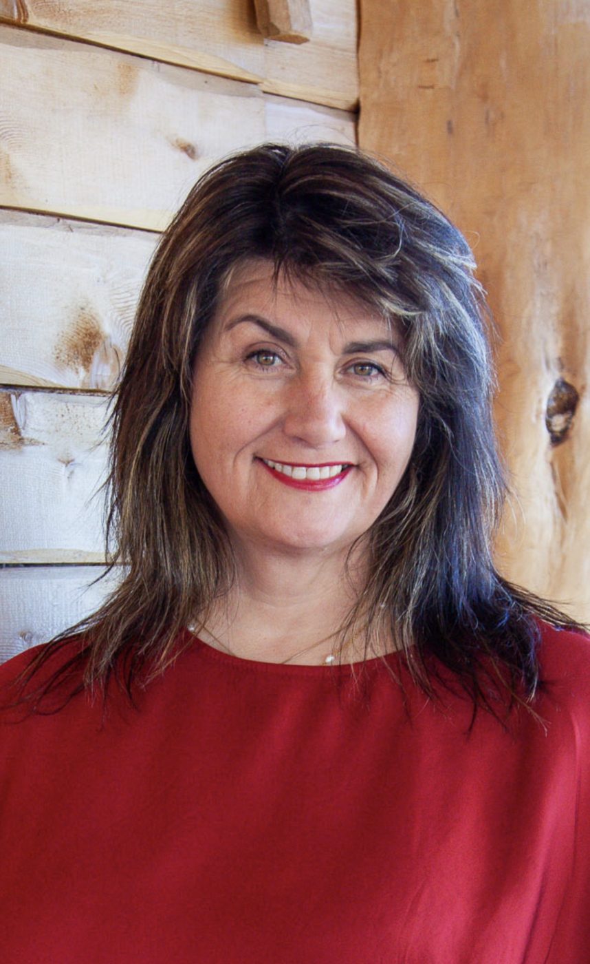 Margrét brosandi við viðarvegg